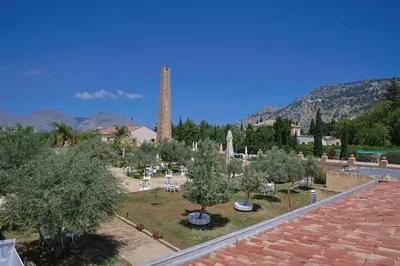 a cemetery with trees and a tower in the background at Villa Lampedusa in Palermo