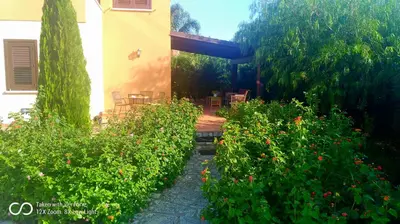 a garden with a house and some bushes and flowers at ViViHolidays in Castellammare del Golfo