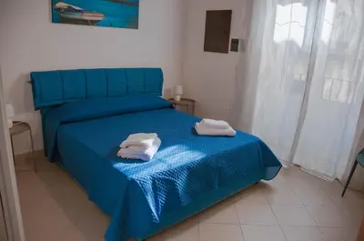 a bedroom with a blue bed with two towels on it at Ideisini's apartment in Palermo