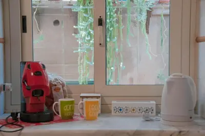 a kitchen counter with a red coffee maker and cups at Ideisini's apartment in Palermo