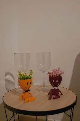 a table with two wine glasses and flowers on it at Ideisini's apartment in Palermo