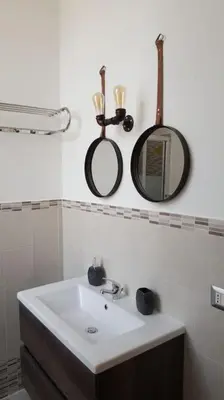 a bathroom with a sink and two mirrors on the wall at Stella D'Oriente in Palermo