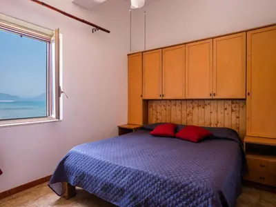 a bedroom with a bed with red pillows and a window at Apartment Luna by Interhome in Trappeto