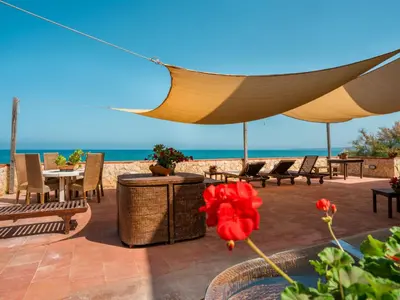 a patio with a table and chairs and the ocean at Apartment Luna by Interhome in Trappeto