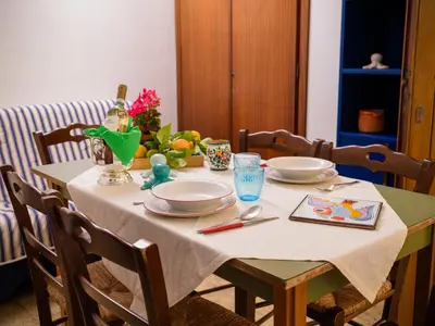a table with a white table cloth and plates on it at Apartment Luna by Interhome in Trappeto