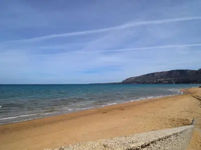 a beach with the ocean and mountains in the background at Apartment Stelle by Interhome in Trappeto
