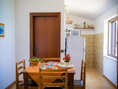 a kitchen and dining room with a table and a refrigerator at Apartment Stelle by Interhome in Trappeto