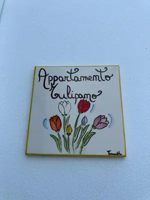a picture of a sign with flowers on a wall at Amalcamo Apartments in Alcamo