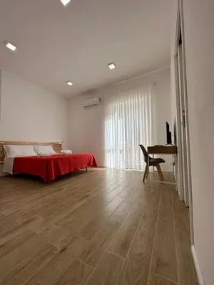 a white room with a bed and a desk in it at Amalcamo Apartments in Alcamo