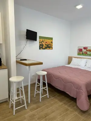 a bedroom with a bed and a table and stools at Amalcamo Apartments in Alcamo
