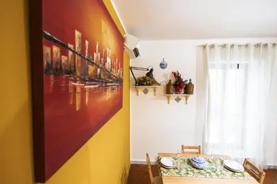 a dining room with a table and a painting on the wall at Ai Bottonai Casa 23 in Palermo