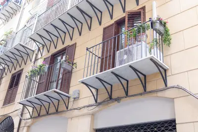 a building with balconies and windows with flowers on it at Ai Bottonai Casa 23 in Palermo