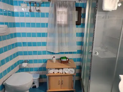 a bathroom with a toilet and a shower and a sink at BONELLUS in Palermo