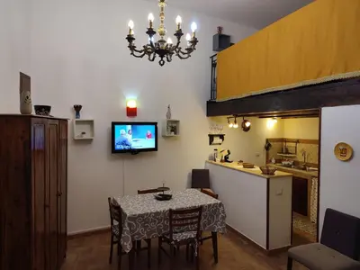 a dining room with a table and a kitchen at BONELLUS in Palermo