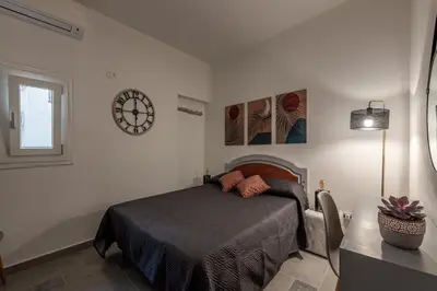 a bedroom with a bed and a clock on the wall at Casa delle Travi by Wonderful Italy in Palermo