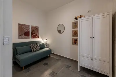 a living room with a green couch and a cabinet at Casa delle Travi by Wonderful Italy in Palermo