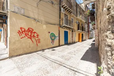 an alley with graffiti on the side of a building at Casa delle Travi by Wonderful Italy in Palermo