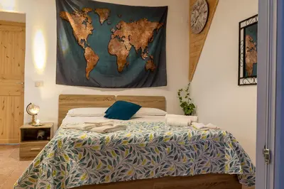 a bedroom with a map of the world hanging on the wall at Casa Lachesi in Caccamo