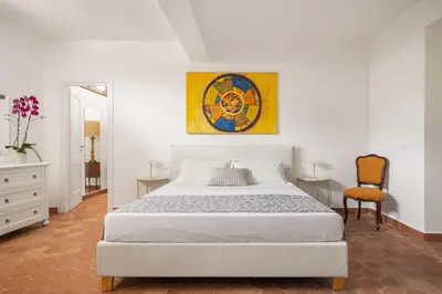 a bedroom with a white bed and a chair at Villa lady olimpia in Palermo