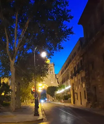 a city street at night with a clock tower at Porta dei Mori Apartment in Palermo