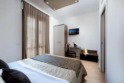 a bedroom with a bed and a desk and a window at Ayres Del Mar in San Vito lo Capo