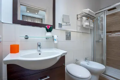 a white bathroom with a sink and a toilet at Ayres Del Mar in San Vito lo Capo