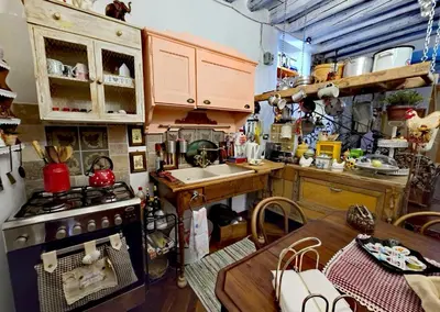 a small kitchen with a stove and a table at A Casa da Paola in Caccamo