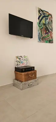 a flat screen tv on a wall with a pile of boxes at Vintage Room Palermo in Palermo