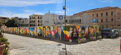 a wall covered in colorful paintings on a city street at Vintage Room Palermo in Palermo