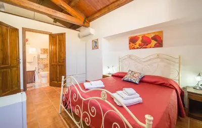 a bedroom with a red bed with towels on it at Casale Del Golfo in Alcamo
