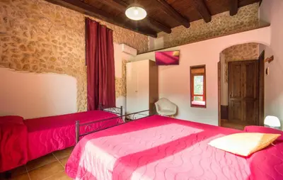 a bedroom with two red beds and a window at Casale Del Golfo in Alcamo