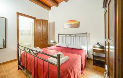 a bedroom with a bed with a red blanket at Casale Del Golfo in Alcamo