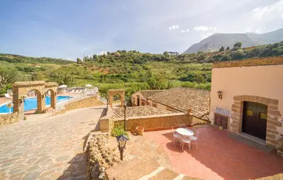 a house with a swimming pool and mountains in the background at Casale Del Golfo in Alcamo