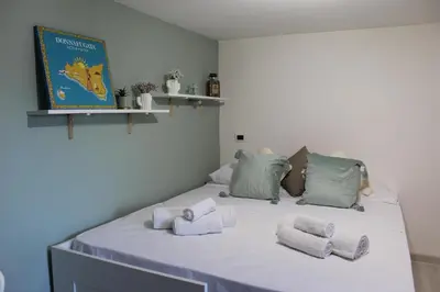 a large white bed with folded towels on it at A' Nica room in Palermo