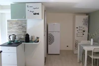 a kitchen with a white refrigerator and a table at A' Nica room in Palermo