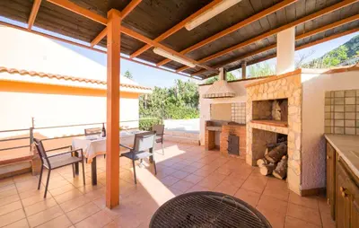 an outdoor patio with a table and a fireplace at Gorgeous Home In Altavilla Milicia in Altavilla Milicia