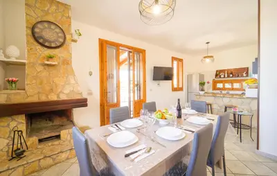 a dining room with a table and a clock on the wall at Gorgeous Home In Altavilla Milicia in Altavilla Milicia