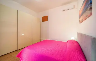 a bedroom with a pink bed in a room at Gorgeous Home In Altavilla Milicia in Altavilla Milicia