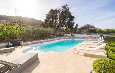 a swimming pool with lounge chairs next to at Gorgeous Home In Altavilla Milicia in Altavilla Milicia