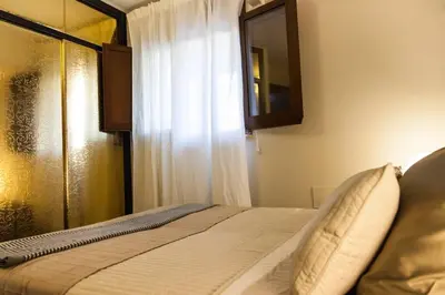 a bedroom with a bed with a window and a mirror at Villa Salvo in Balestrate