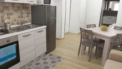 a kitchen with a table and a stainless steel refrigerator at Casa Chiaretta in Palermo