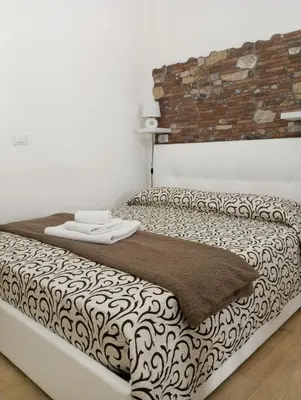 a bed in a room with a brick wall at Casa Chiaretta in Palermo