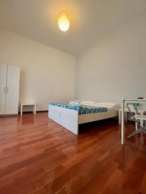 a bedroom with a bed and a wooden floor at Castelnuovo Rooms #Politeama in Palermo