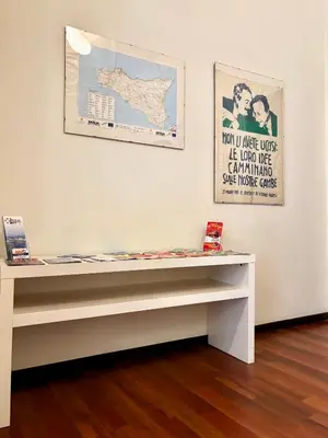 a bench in a gallery with a poster on the wall at Castelnuovo Rooms #Politeama in Palermo