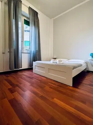 a bedroom with a bed and a wooden floor at Castelnuovo Rooms #Politeama in Palermo
