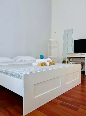 a white bed in a room with a desk at Castelnuovo Rooms #Politeama in Palermo
