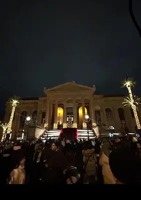 a crowd of people in front of a building at night at Palermo Houses in Palermo