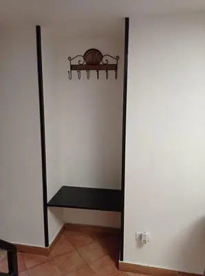 a hallway with a shelf and a white wall at casa centro storico O Capu in Palermo