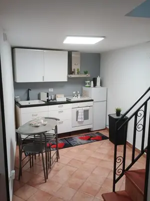 a kitchen with a table and a kitchen with a counter at casa centro storico O Capu in Palermo