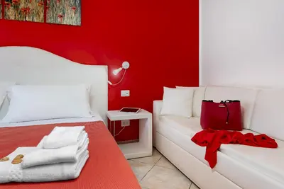 a red room with a bed and a red wall at B&B Armonie in San Vito lo Capo